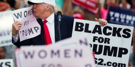 Image: Trump kisses a \"Women for Trump\" sign during a campaign rally