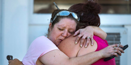 Image: Carrie Matula embraces a woman after a fatal shooting