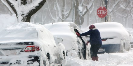 Image: A woman clears a car in the snow during a winter storm in Buffalo, New York
