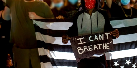 People hold up their fists after protesting near the spot where George Floyd died while in custody of the Minneapolis Police, on May 26, 2020 in Minneapolis