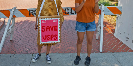 Protesters rally outside the home of USPS Board of Governors John M. Barger to decry recent cuts by Postmaster General Louis DeJoy that could affect presidential election mail-in ballots in San Marino, Calif., on Aug. 22, 2020