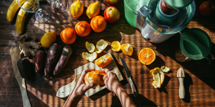 Woman's hands peeling orange for squeezing juice