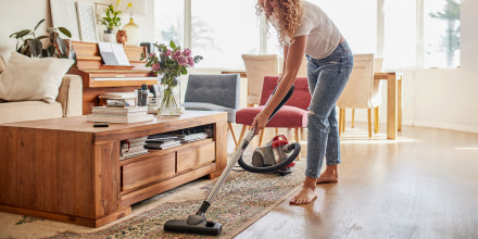Woman vacuuming her living room with her heavy duty carpet cleaner