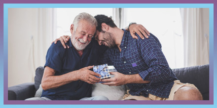 Son Giving Father Gift While Sitting On Sofa At Home