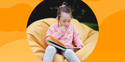 Little girl on beanbag chair reading a book