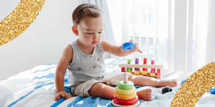 Toddler Playing With Learning Toy Pyramid Stacking Blocks At Home