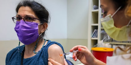 Image: A health worker administers a third dose of the Pfizer-BioNtech COVID-19 vaccine on a woman at the Maccabi Health Service in Jerusalem, on July 30, 2021, as Israel launches its campaign to give booster shots to people aged over 60.