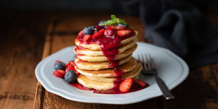 Tasty Pancakes With Berry Sauce On Wooden Table