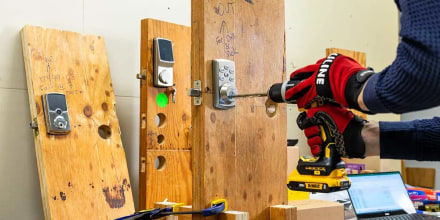 A Consumer Reports engineer uses a cordless drill to test door locks.