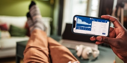 Image: Man holding mobile phone and analyzing cryptocurrency trends