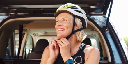 Woman putting on cycling helmet