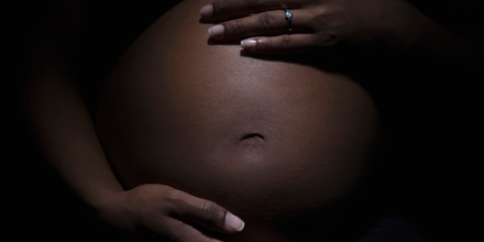 Close up of mixed race woman's pregnant stomach