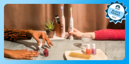 Lifestyle image of toothbrushes and hand painting nails