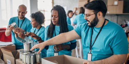 Diverse volunteers packing donation boxes in charity food bank