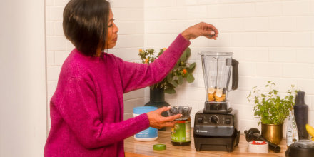 Woman prepping a smoothie with her Blender