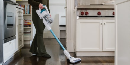 Woman vacuuming in her kitchen