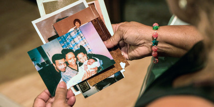 Maria Velazquez holds a stack of family photos in her hands. One of the photos shows her son, JJ Velazquez, smiling with his then-girlfriend, Vanessa Cepero, and their two sons.