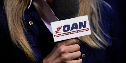 A reporter with One America News Network works at a campaign rally with President Donald Trump on Sept. 25, 2020, in Newport News, Va.
