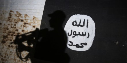 A member of the Iraqi forces walks past a mural bearing the logo of the Islamic State group on March 1, 2017, in the village of Albu Sayf, on the southern outskirts of Mosul.