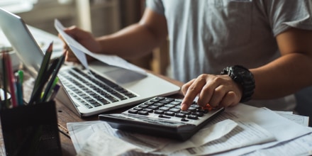 Men is calculating the cost of the bill. She is pressing the calculator.
