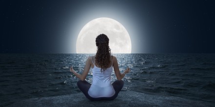 persona meditando frente luna llena