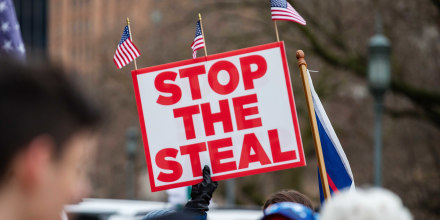 A protester holds a "stop the steal" placard during a pro-