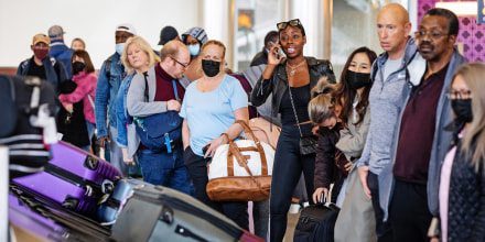 Travelers, some wearing masks,  at Hartsfield-Jackson Atlanta International Airport on April 19, 2022, one day after a federal judge struck down the mask mandate on airplanes, trains and other public transportation.