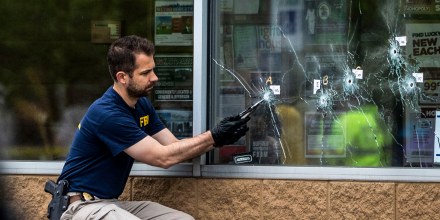 Bullet holes are seen in the window of Tops Friendly Market at Jefferson Avenue and Riley Street, as federal investigators work the scene of a mass shooting on May 16, 2022 in Buffalo, N.Y.