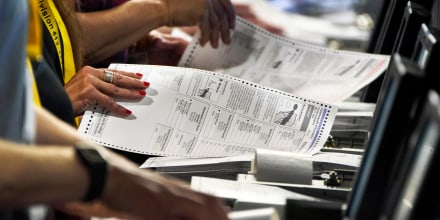 Election workers perform a recount of ballots