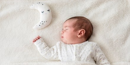 Baby boy in bed sleeping with moon