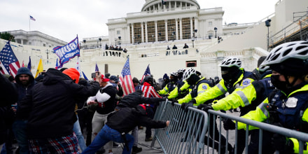 Simpatizantes del presidente Donald Trump trataban de tumbar las barreras custodiadas por la policía el 6 de enero de 2021, en Washington.