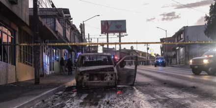 Policías acordonan la zona en donde se halló un vehículo incinerado en Tijuana, Baja California, México, el viernes 12 de agosto de 2022.