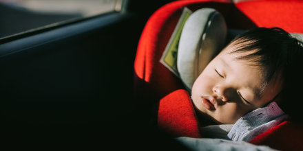 Portrait of baby sleeping in carseat.