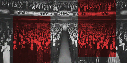 Image: Theater audience standing in formal attire, applauding