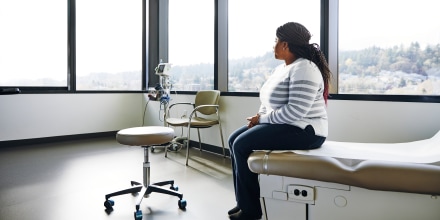 Una mujer se sienta en la camilla de un hospital.