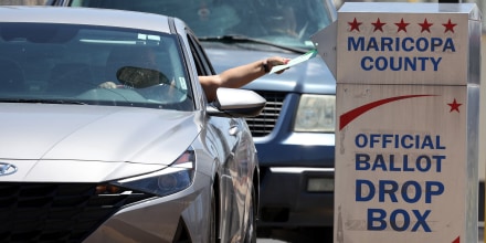 A voter places a ballot in a drop box outside of the Maricopa County Elections Department on Aug. 2, 2022 in Phoenix.