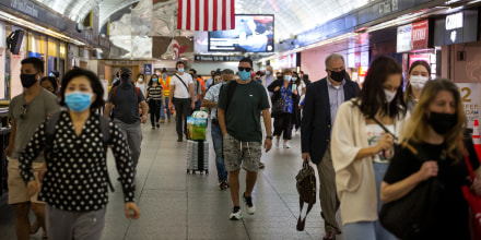 Commuters with protective masks walk through Pennsylvania Station in New York on Aug. 3, 2020.