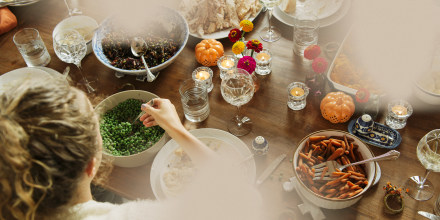 Teenage girl having food while sitting at dining table during Thanksgiving. 