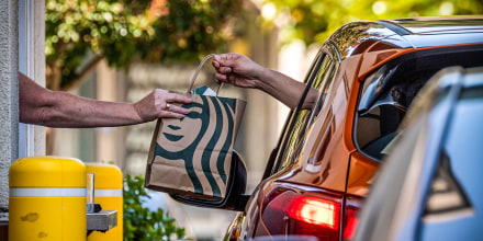 An employee hands a bag to a customer at the drive-thru of a Starbucks coffee shop in Hercules, Calif., on July 28, 2022.