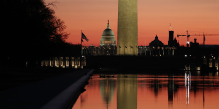 Image: The Capitol is seen behind the Washington Monument across from the Reflecting Pool at dusk.