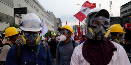 Manifestantes antigubernamentales usan cascos y máscaras antigás en Lima, Perú, el martes 31 de enero de 2023.