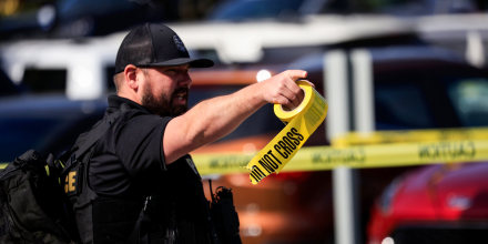 A police officer carries a roll of crime scene tape after a gunman opened fire at the Old National Bank building on April 10, 2023, in Louisville, Ky.
