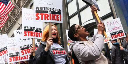 Members of the Writers Guild of America (WGA) East hold signs as they walk on the picket-line outside of the Peacock NewFront on May 02, 2023 in New York City. WGA members were out on the first day of a Hollywood voters strike after the board of directors for the Writers Guild of America, which includes West Coast and East Coast branches, voted unanimously to call for a walkout. Negotiations between a top guild and a trade association that represents Hollywoodâ€™s top studios failed to avert the first walkout in more than 15 years. Union members have stated that they are not being paid fairly in the streaming era and are seeking pay increases and structural changes to the business model.