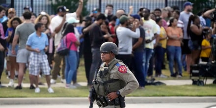 A law enforcement officer walks as people are evacuated from a shopping center where a shooting occured Saturday, May 6, 2023, in Allen, Texas.