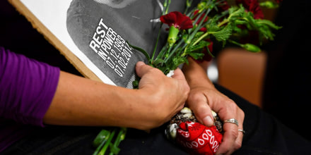 Las manos de April Sanchez, una mujer con anillos en los dedos, sostienen una foto. Es una imagen de Ryan Ronquillo, hijo de Sanchez y quien murió tras un encuentro con la policía de Denver, Colorado, en 2014