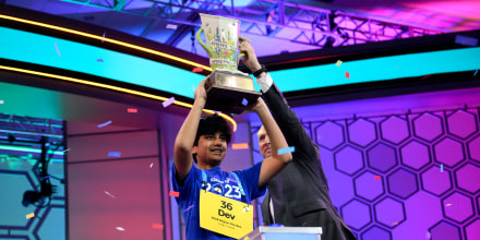 Dev Shah, de 14 años, de Largo, Florida, levanta el trofeo junto al director ejecutivo de Scripps, Adam Symson, tras ganar la final del Concurso Nacional de Ortografía Scripps, el jueves 1 de junio de 2023, en Oxon Hill, Maryland.