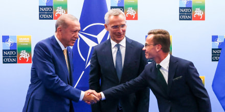 Turkish President Tayyip Erdogan, left, and Swedish Prime Minister Ulf Kristersson shake hands next to NATO Secretary-General Jens Stoltenberg on the eve of a NATO summit in Vilnius, Lithuania, on July 10, 2023.