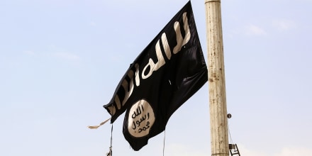 A member of the US-backed Syrian Democratic Forces removes an ISIS flag in Taqba, Syria, on April 30, 2017.