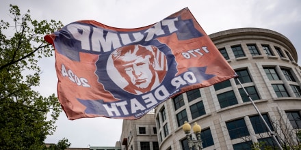 A supporter of former President Donald Trump flies a flag outside of the E. Barrett Prettyman United States Courthouse on Aug. 3, 2023.