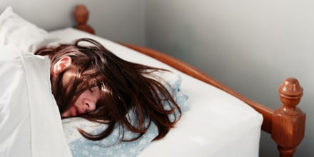 Young woman sleeping in bed